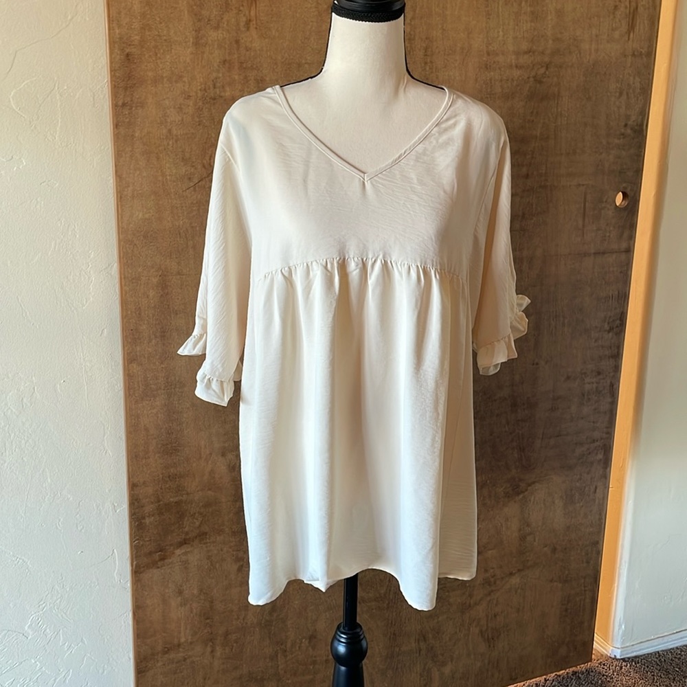 Cream colored oversized blouse.